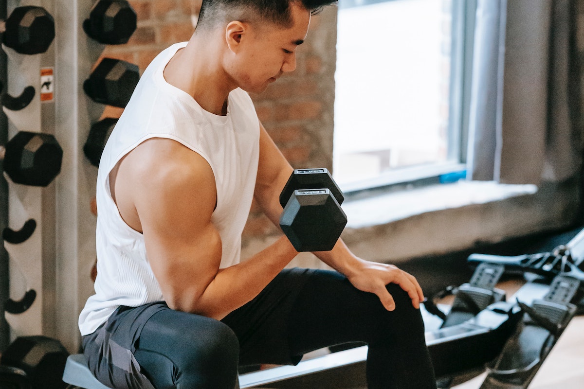 Man doing concentration curls white shirt